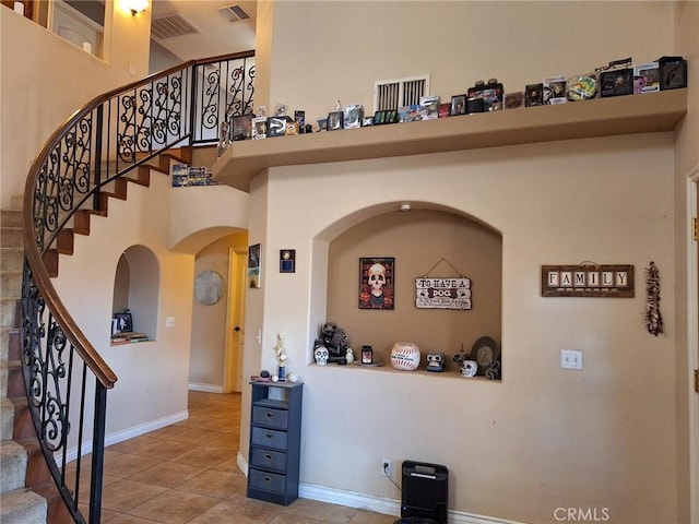 tiled foyer entrance featuring a towering ceiling