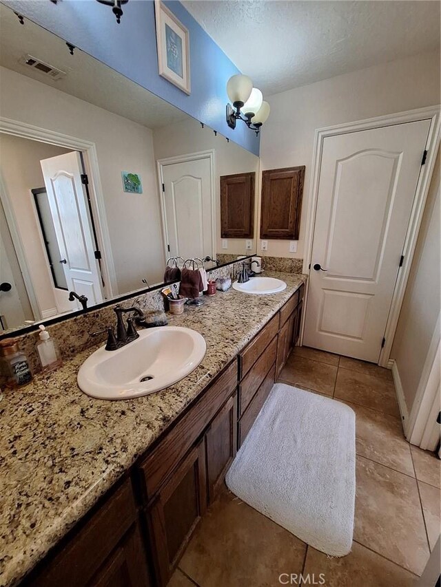 bathroom featuring a textured ceiling, tile patterned flooring, and vanity