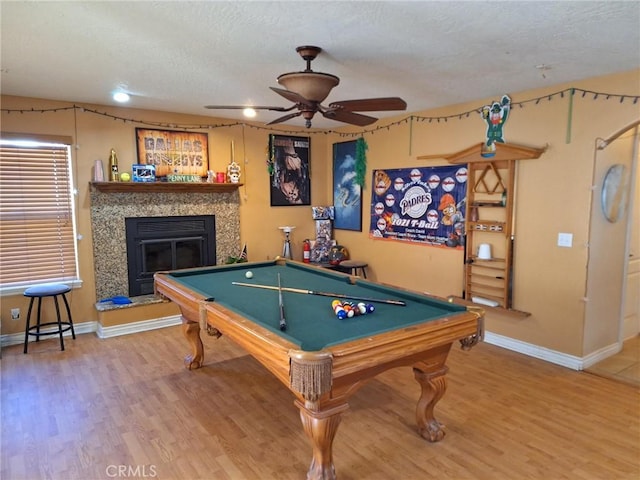 recreation room with hardwood / wood-style flooring, billiards, ceiling fan, and a fireplace