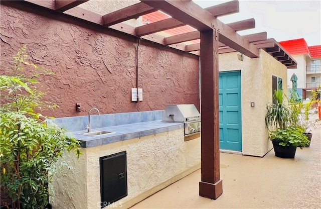 view of patio with a pergola, area for grilling, sink, and exterior kitchen