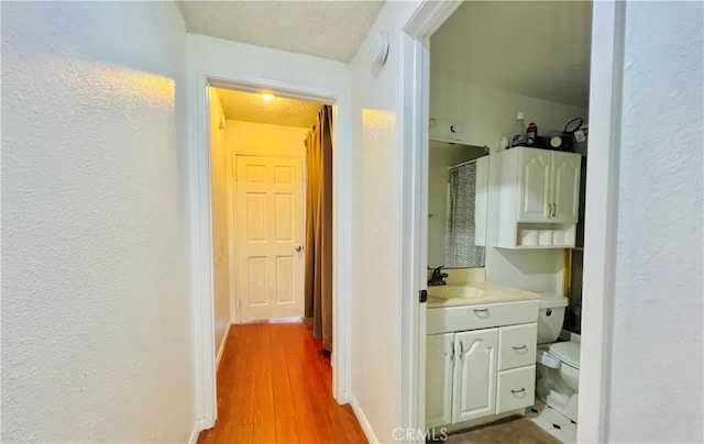 bathroom with vanity, wood-type flooring, a textured ceiling, and toilet