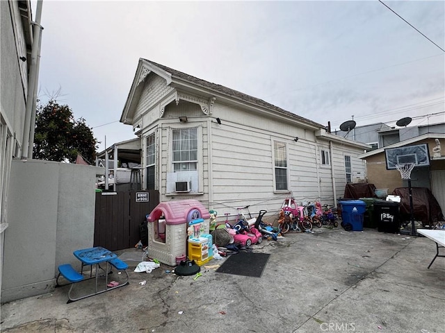 view of home's exterior with fence, cooling unit, and a patio