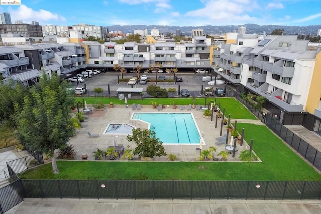 view of pool with a patio, a mountain view, and a yard