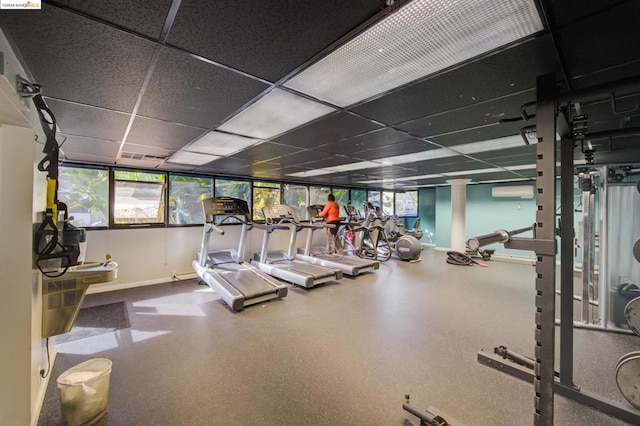 exercise room featuring a drop ceiling and a wall unit AC