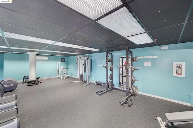 gym featuring a paneled ceiling and a wall unit AC