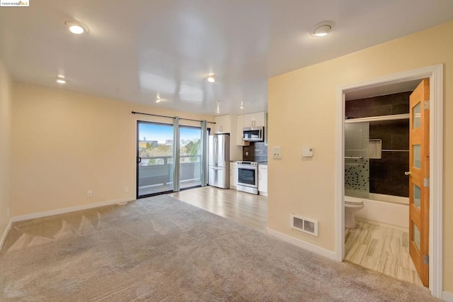 unfurnished living room featuring light carpet