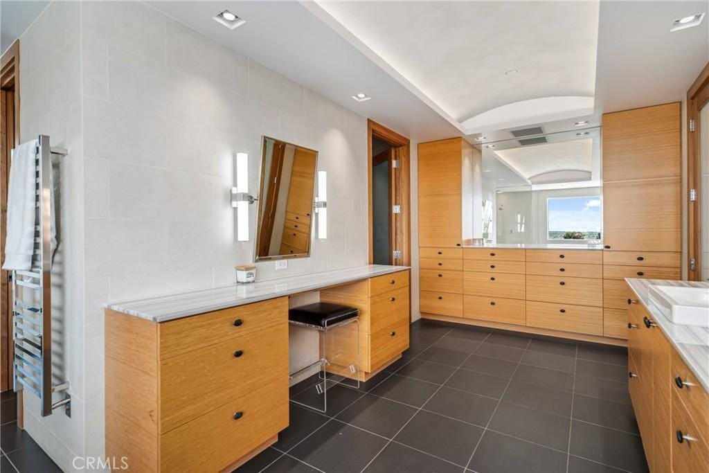 full bath featuring tile patterned flooring, tile walls, and vanity