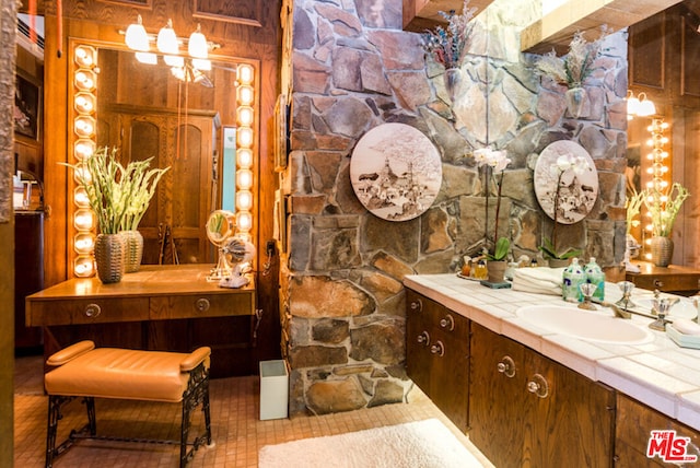 bathroom with vanity and wood walls