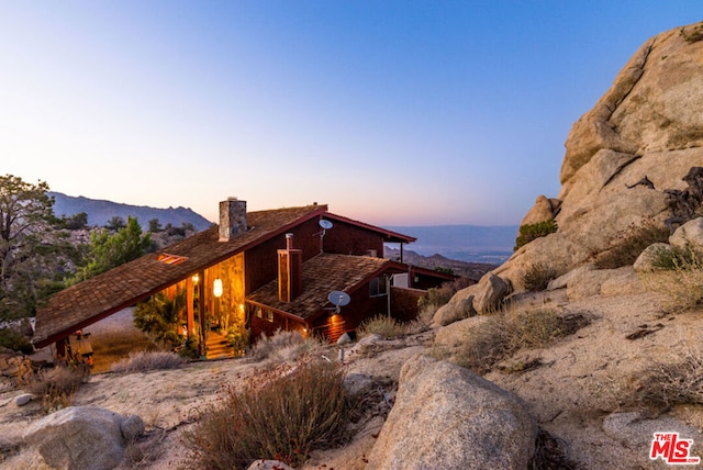 property exterior at dusk with a mountain view