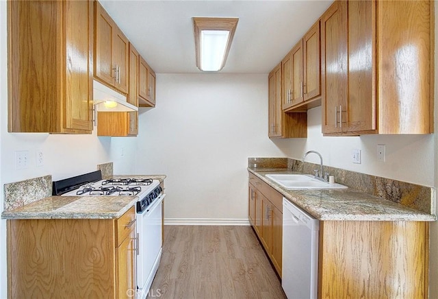 kitchen featuring light wood-style flooring, a sink, white appliances, under cabinet range hood, and baseboards