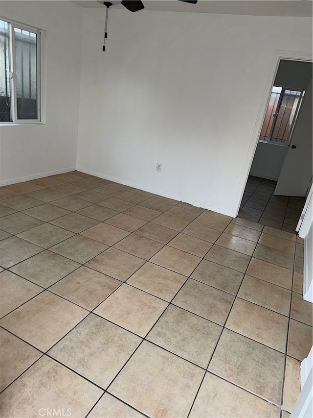 spare room with ceiling fan and light tile patterned floors