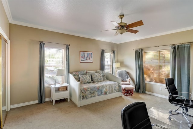 bedroom with ceiling fan, crown molding, light colored carpet, and a textured ceiling