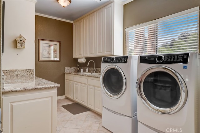 laundry area with washing machine and dryer, crown molding, sink, and cabinets