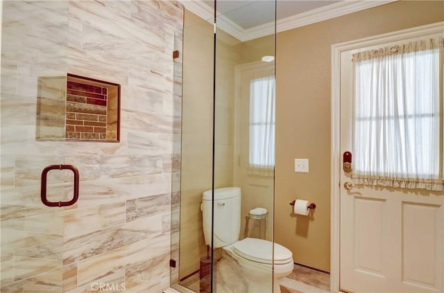 bathroom featuring toilet, a shower with shower door, and ornamental molding