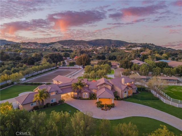 aerial view at dusk featuring a mountain view