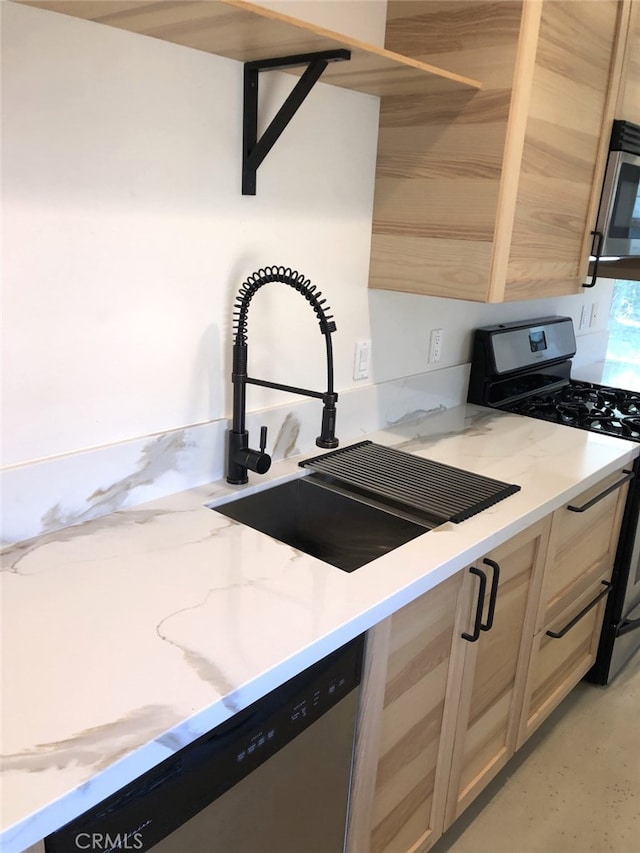 kitchen featuring stainless steel appliances, light stone countertops, sink, and light brown cabinets