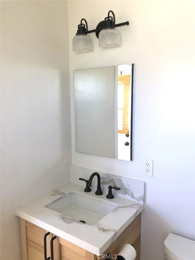 bathroom featuring vanity and toilet