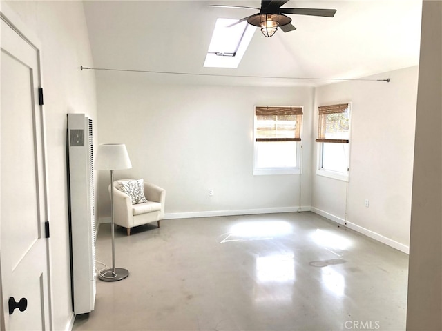 unfurnished room with a skylight, concrete flooring, and ceiling fan