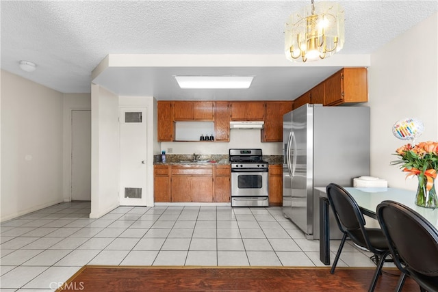 kitchen featuring sink, an inviting chandelier, appliances with stainless steel finishes, light tile patterned floors, and decorative light fixtures