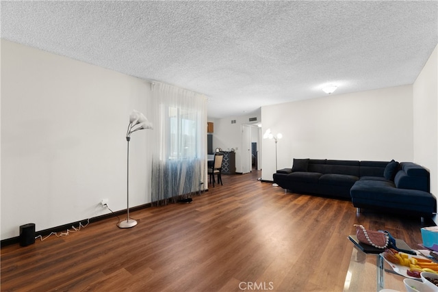 living room featuring a textured ceiling and dark hardwood / wood-style flooring