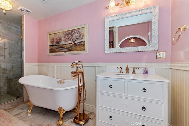 full bath with vanity, wainscoting, a freestanding bath, and a stall shower