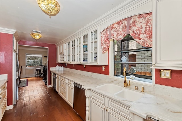 kitchen with ornamental molding, sink, appliances with stainless steel finishes, light stone countertops, and dark hardwood / wood-style flooring