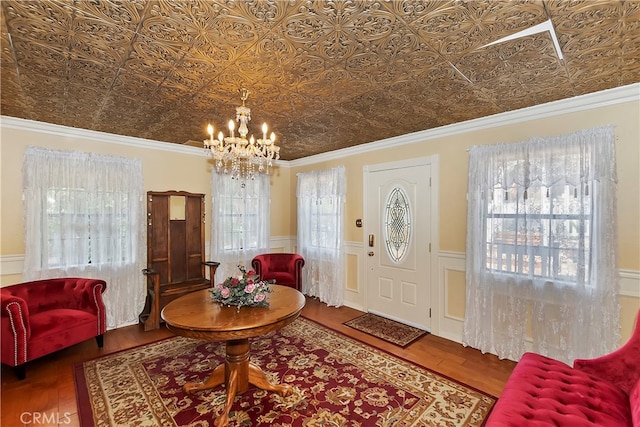 entrance foyer featuring hardwood / wood-style flooring, plenty of natural light, and ornamental molding