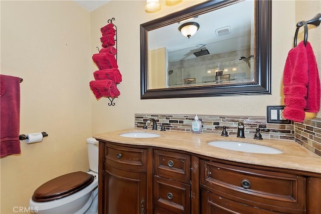 full bathroom featuring double vanity, a sink, decorative backsplash, and toilet