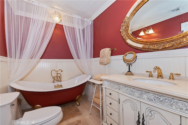 bathroom with ornamental molding, vanity, toilet, and a bath