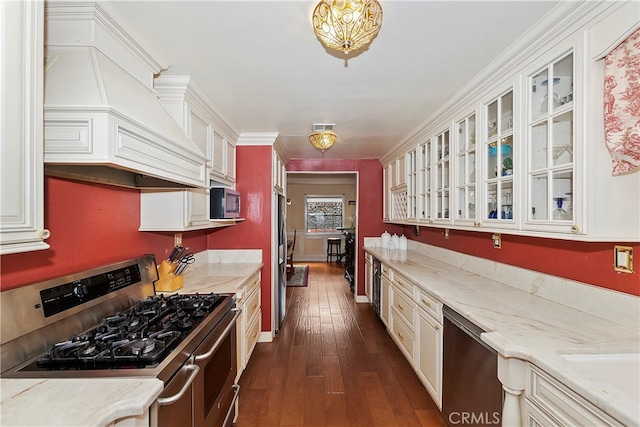 kitchen featuring custom range hood, white cabinets, light stone countertops, stainless steel appliances, and dark hardwood / wood-style floors