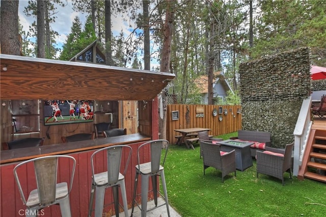 view of yard featuring an outdoor living space with a fire pit, fence, and outdoor dry bar