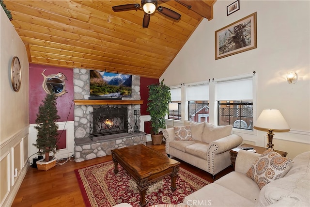 living room featuring wood ceiling, a fireplace, wood-type flooring, beam ceiling, and ceiling fan