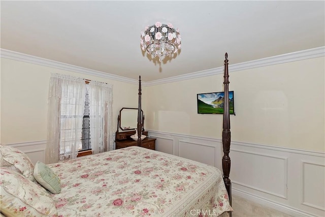 carpeted bedroom featuring crown molding, wainscoting, and a decorative wall