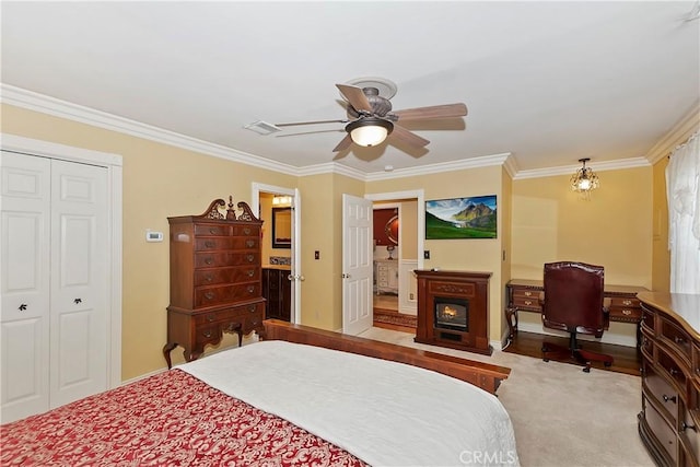 carpeted bedroom featuring ceiling fan, visible vents, ornamental molding, and a closet