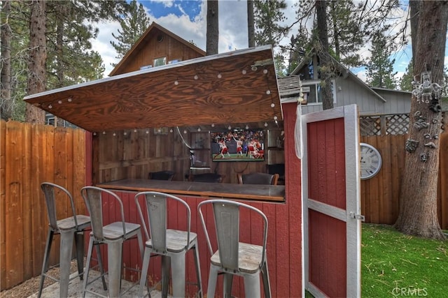 view of patio / terrace featuring fence and outdoor dry bar