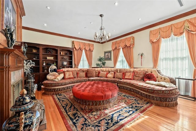 living room featuring hardwood / wood-style flooring, plenty of natural light, ornamental molding, and a chandelier