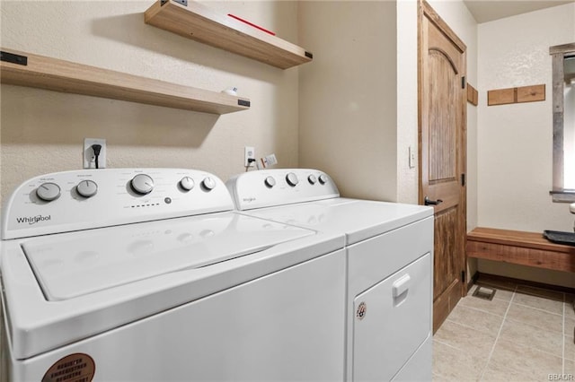 laundry room featuring independent washer and dryer and light tile patterned floors