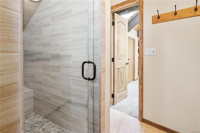 bathroom with a shower with shower door and tile patterned flooring