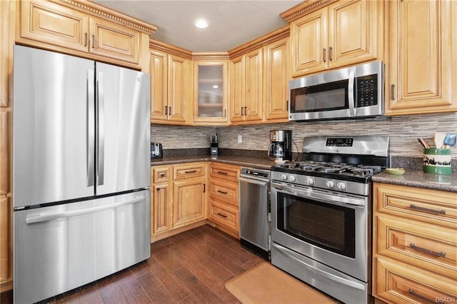 kitchen with dark wood-type flooring, backsplash, stainless steel appliances, and light brown cabinetry