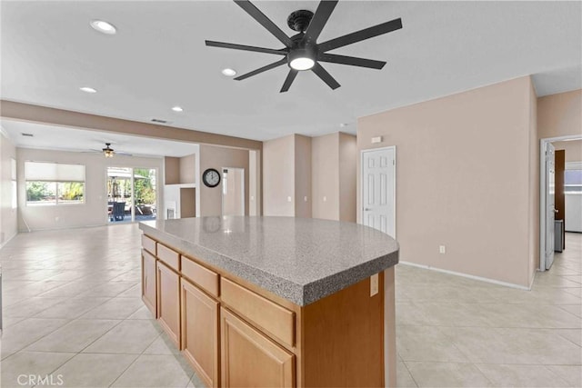 kitchen featuring light tile patterned floors, recessed lighting, a kitchen island, open floor plan, and light countertops