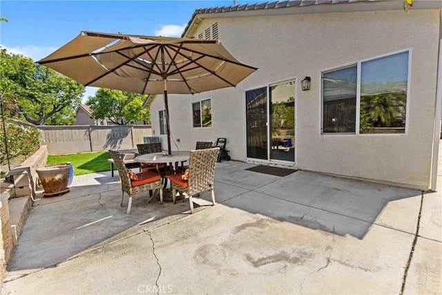 view of patio featuring outdoor dining area and fence