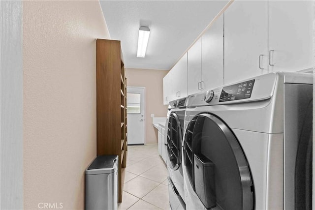 laundry room featuring light tile patterned floors, cabinet space, and washer and dryer