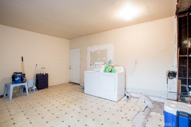 clothes washing area with light floors, laundry area, and washing machine and clothes dryer