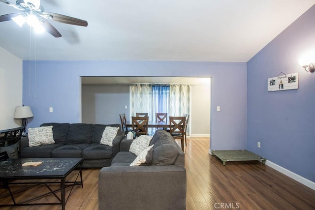 living room with a ceiling fan, lofted ceiling, baseboards, and wood finished floors