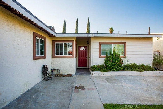 property entrance with a patio area and stucco siding