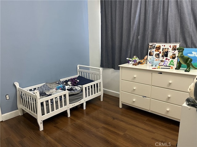 bedroom featuring dark wood-style floors and baseboards