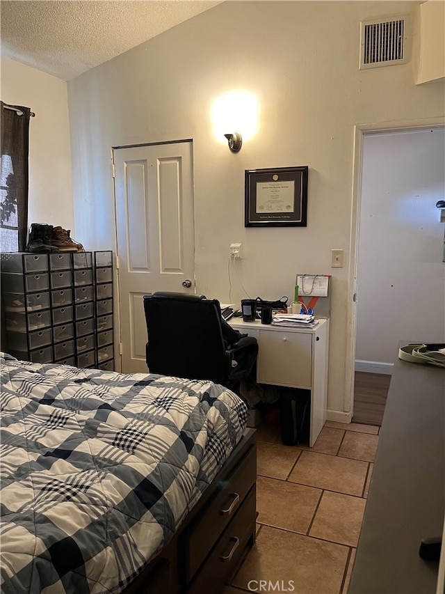 bedroom with visible vents, vaulted ceiling, a textured ceiling, and light tile patterned flooring