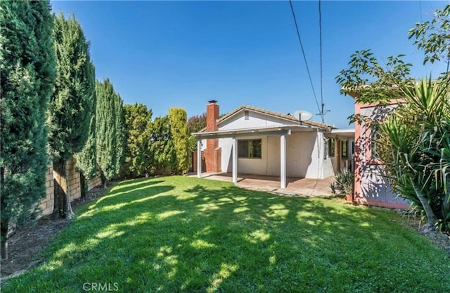 back of house with a yard and a patio