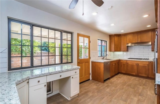 kitchen with white cabinetry, sink, decorative backsplash, stainless steel dishwasher, and light stone counters