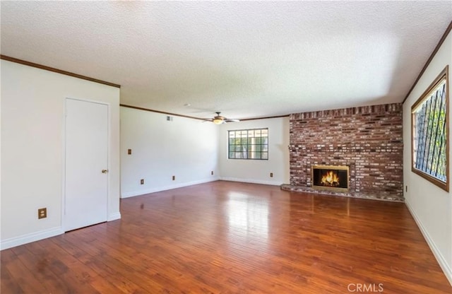 unfurnished living room featuring crown molding, hardwood / wood-style floors, a textured ceiling, and a fireplace